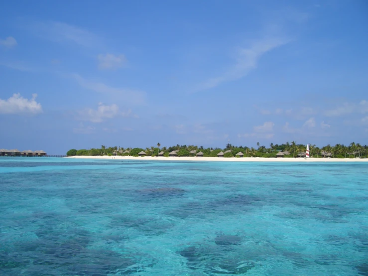 an ocean view with a blue sky and the white sandy beach