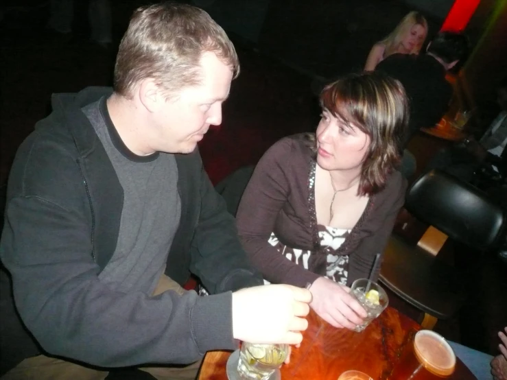 people are seated at a table in a bar