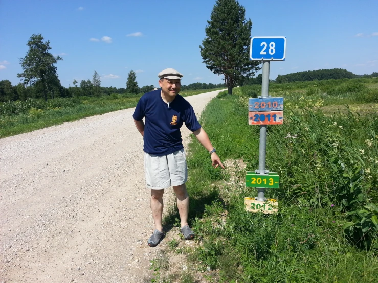 a man standing next to a road sign and a sign that says'no left turn '