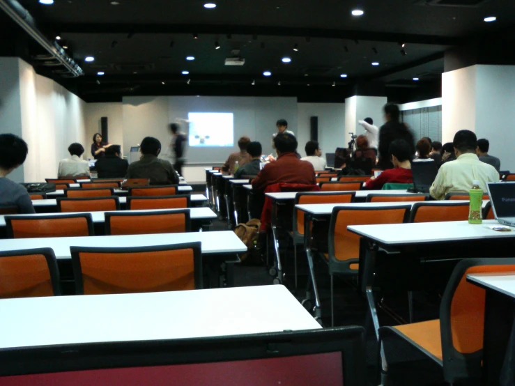 people are seated at their desks in the classroom