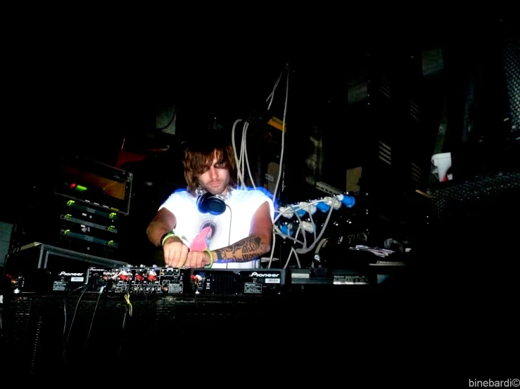 man using laptop behind mixing station at night