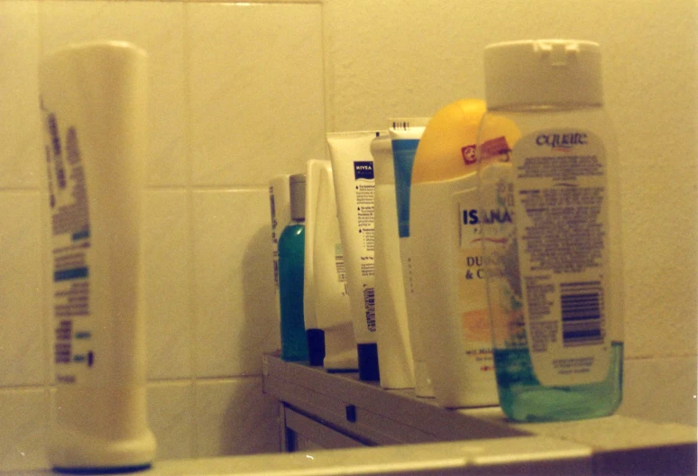 different bottles of toothpaste sitting on top of a bathroom counter