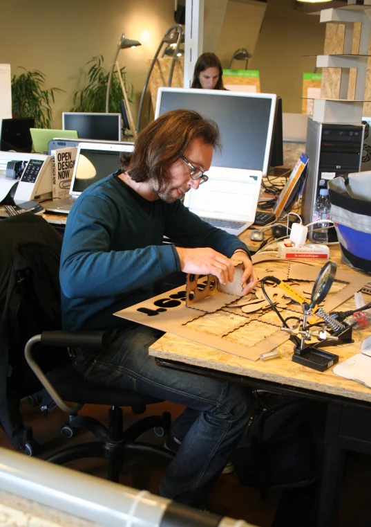 two people working at their desk, both of them are using laptops