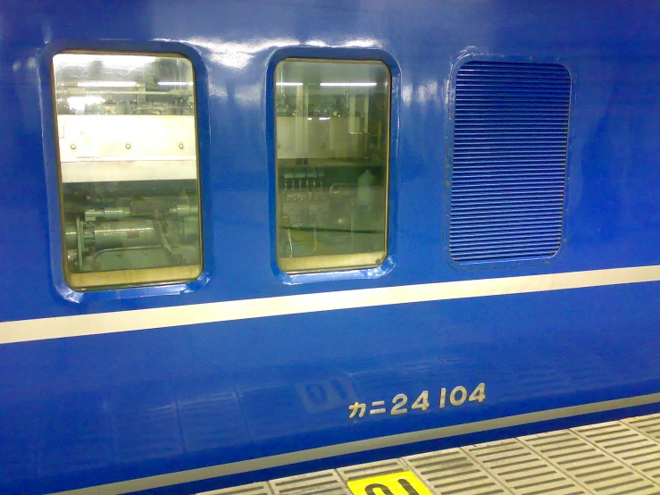 the side of a blue passenger train next to a platform