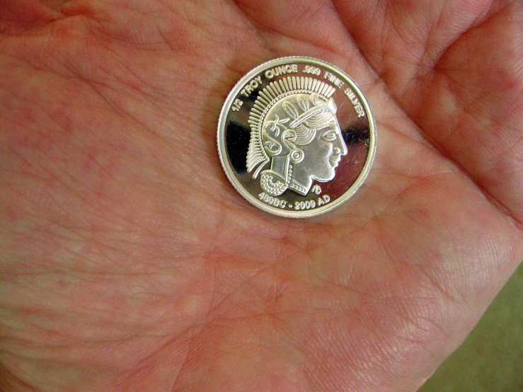 a coin that is on the palm of someone's hand