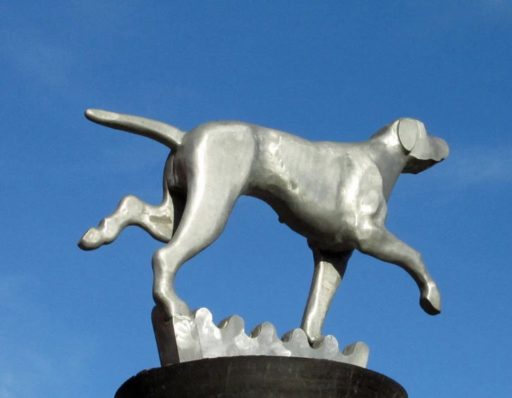 a metal statue of a dog and a alligator on the side of a street