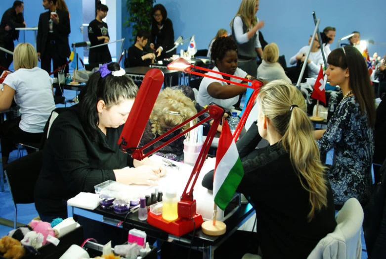 a group of people sitting around a table making decorations