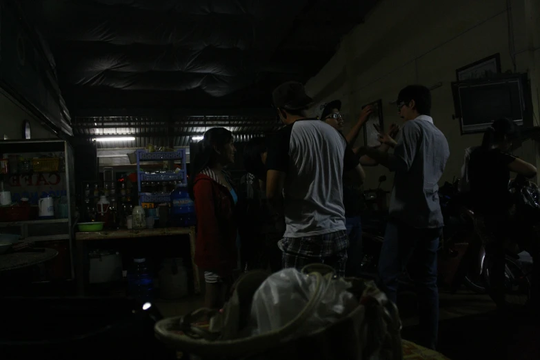 a group of young men talking while standing in a garage