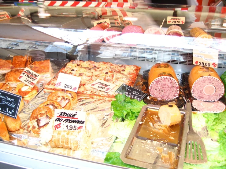 a bunch of food is behind glass on display