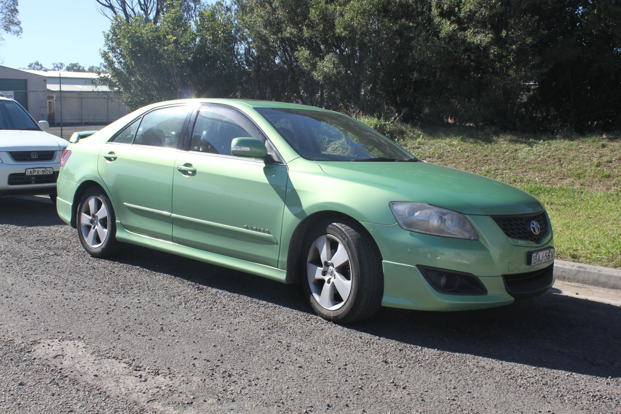 a green car is parked near the other cars