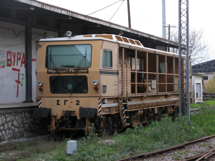 the back end of a yellow train car at a train station