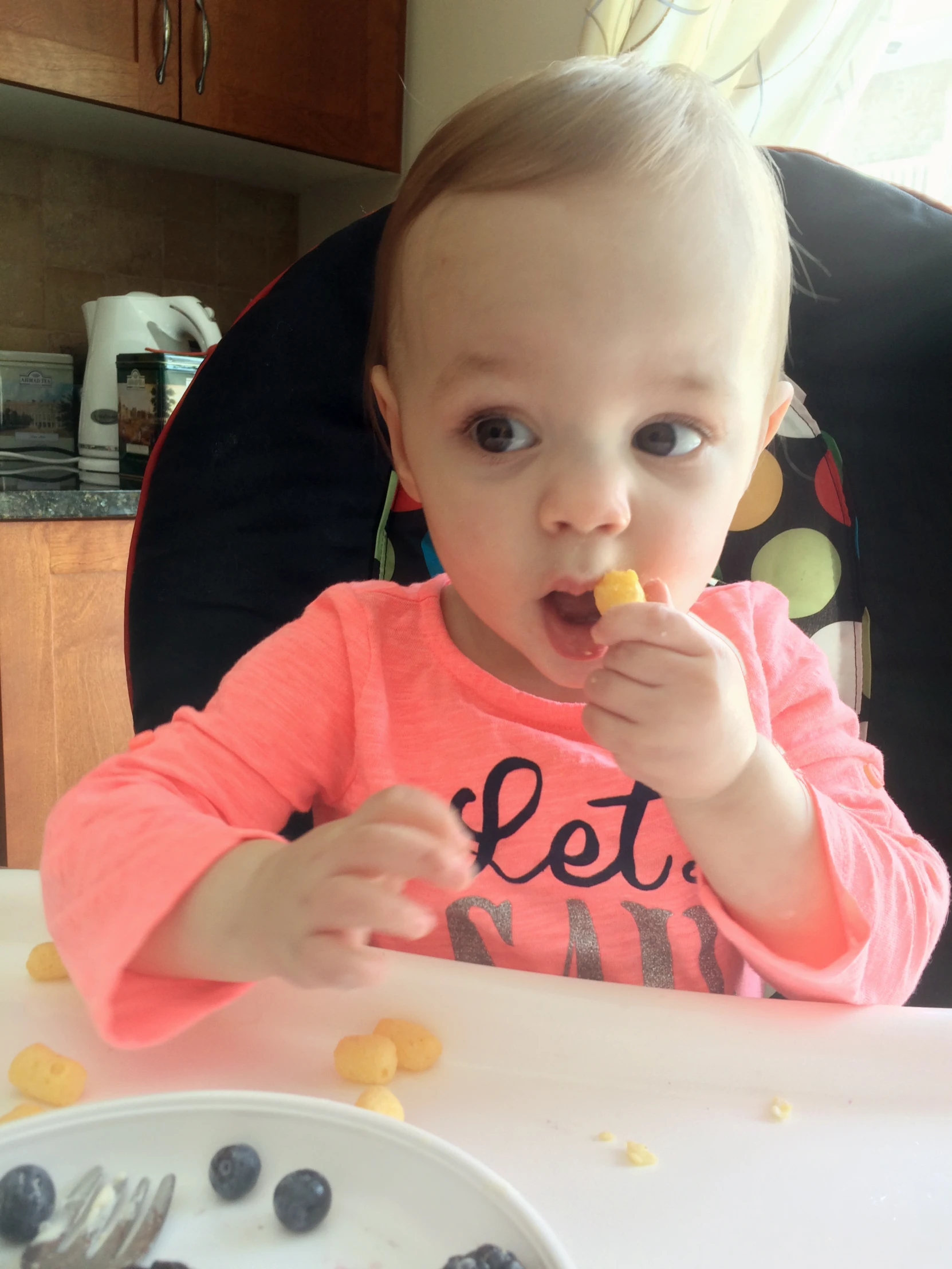 a baby eating soing from a white plate