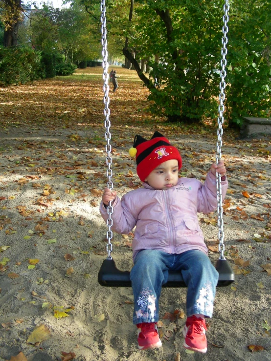 a young child is sitting on a swing