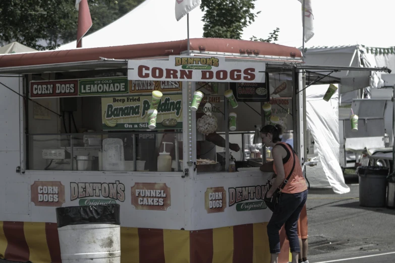 a woman ordering from a food truck on a city street