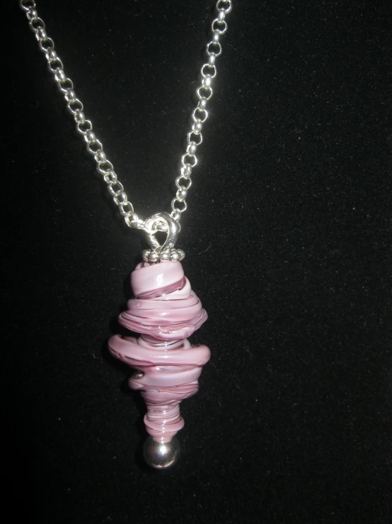 a silver necklace with pink glass on a chain