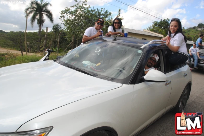 four people in a car with a sky view