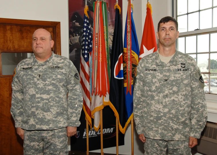 two soldiers standing in front of flags and hanging them