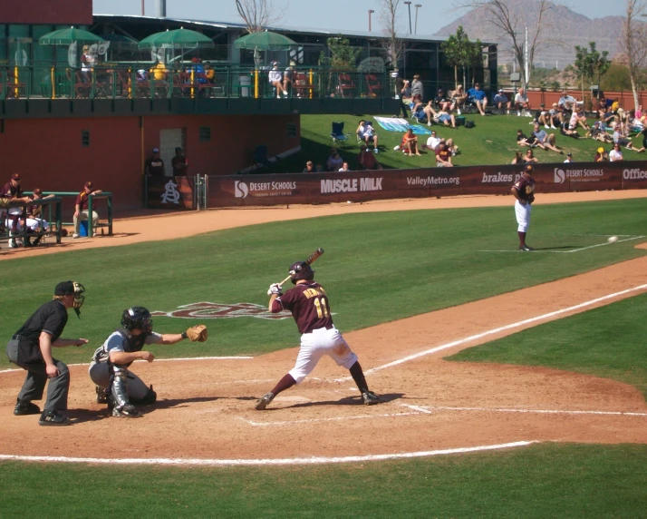 a baseball player at home plate taking a swing at the ball