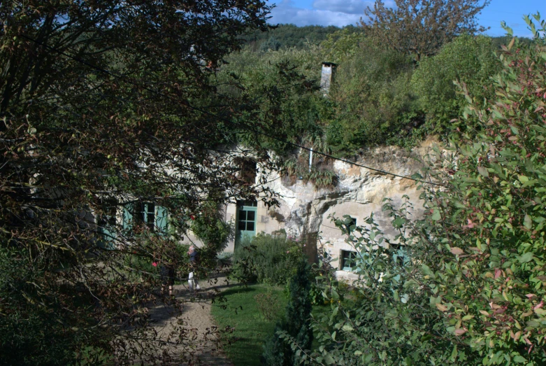 a small road on a hillside with green doors and windows