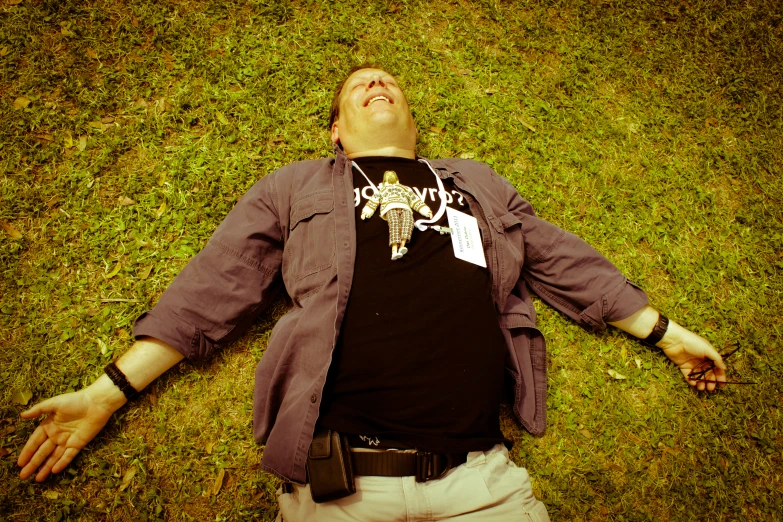 man lies on a lawn and looks up