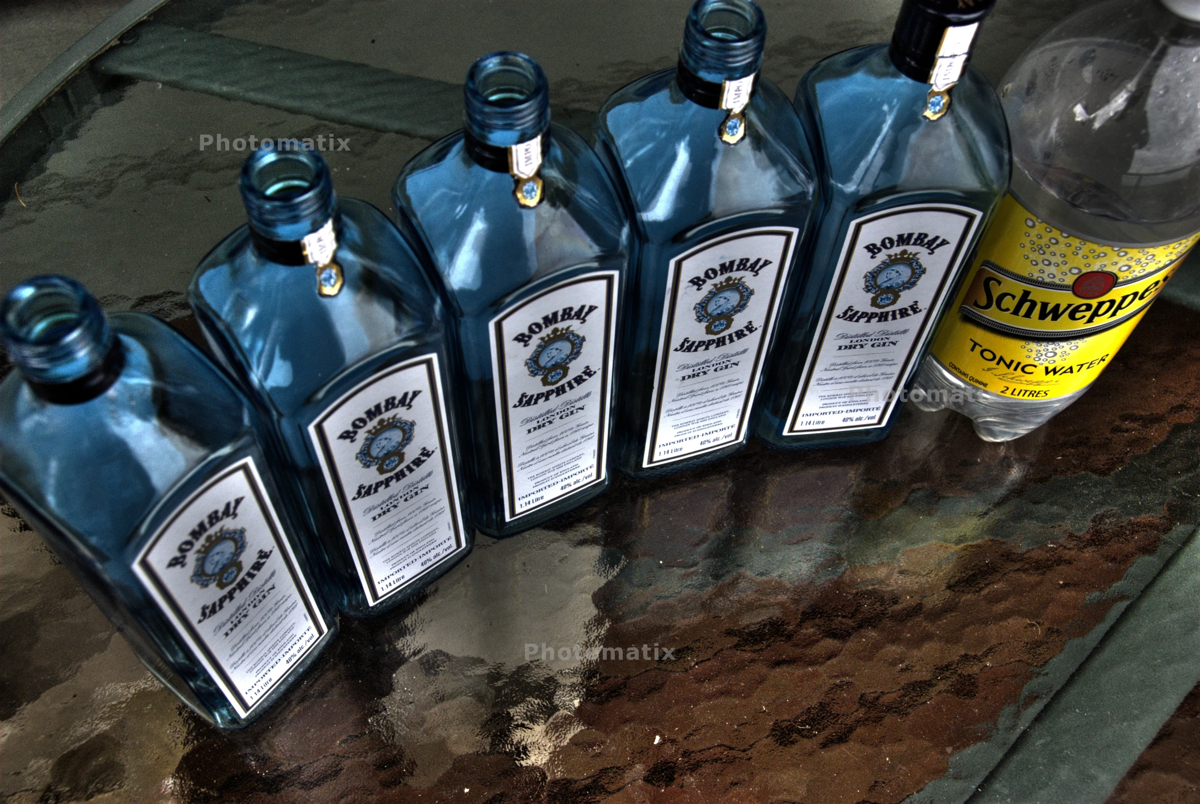 five blue bottles of liquor on a table