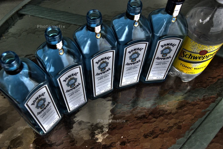 five blue bottles of liquor on a table