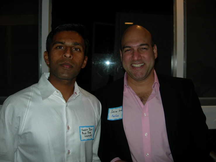 two men smile together in front of the camera