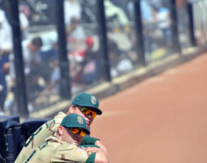 there are two men that are sitting in a dugout