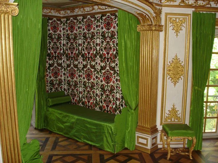 there is an elegant green room with gold trim around the wall