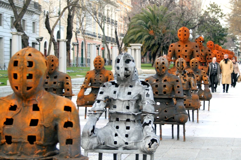a group of metal figures that are sitting on benches