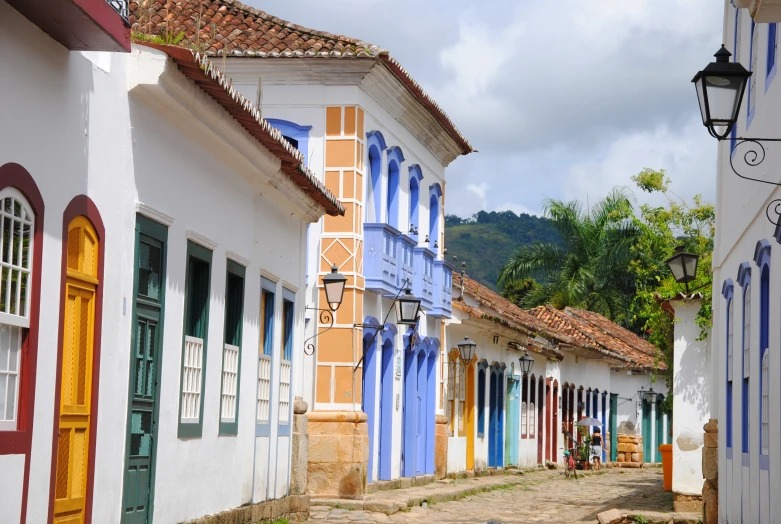 several colorfully painted buildings are along a sidewalk