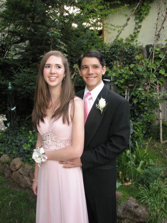 a young couple in formal dress posing for the camera