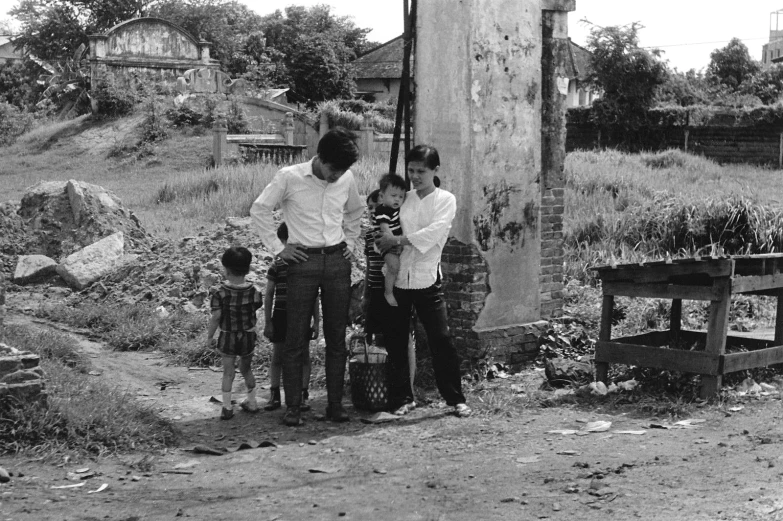 three men are standing in front of an old barn