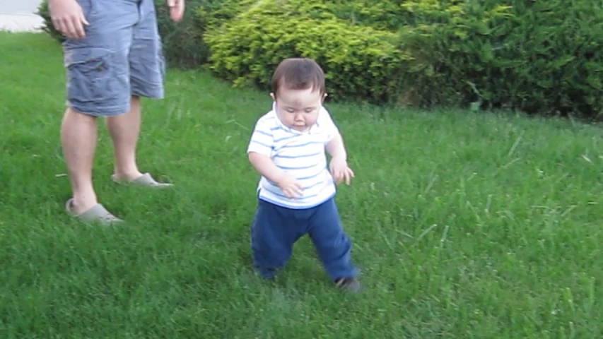 there is a small boy standing in the grass