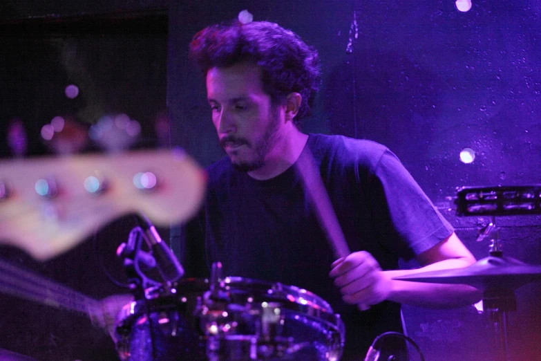 a man plays drums while in the dark