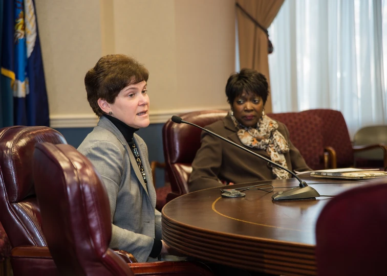 the woman is sitting next to a microphone