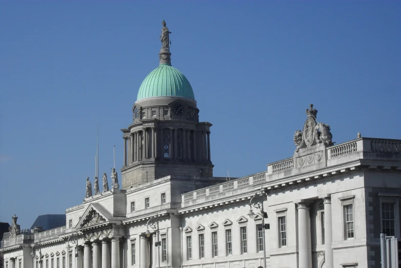 a building with a tall tower has a green dome