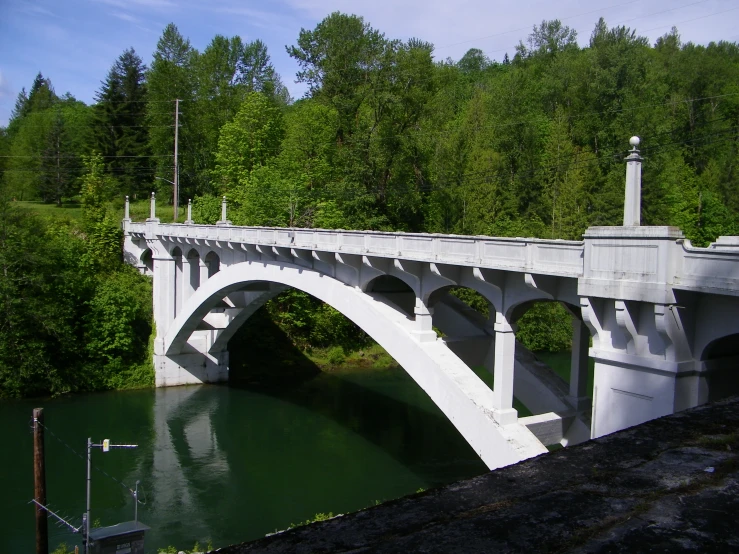 the bridge is white with many columns and a cross at it