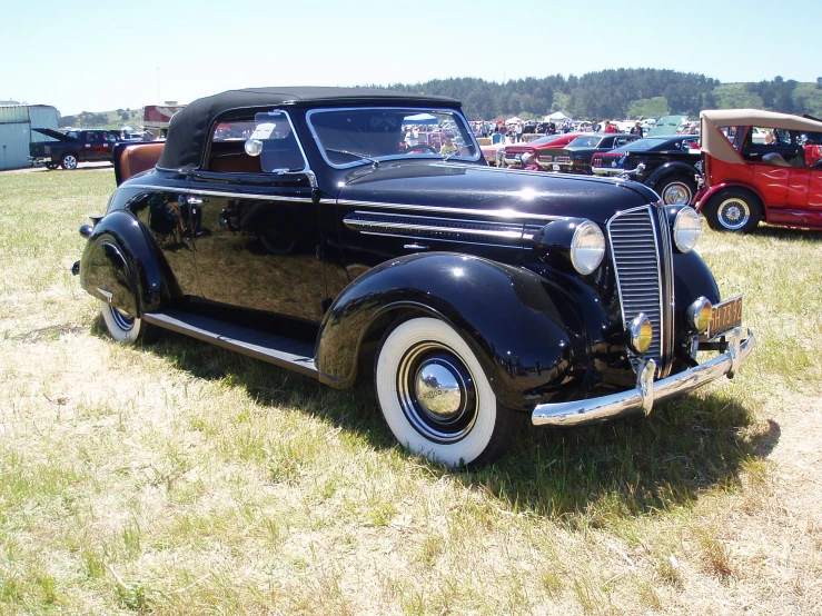 an old fashioned car parked on a field