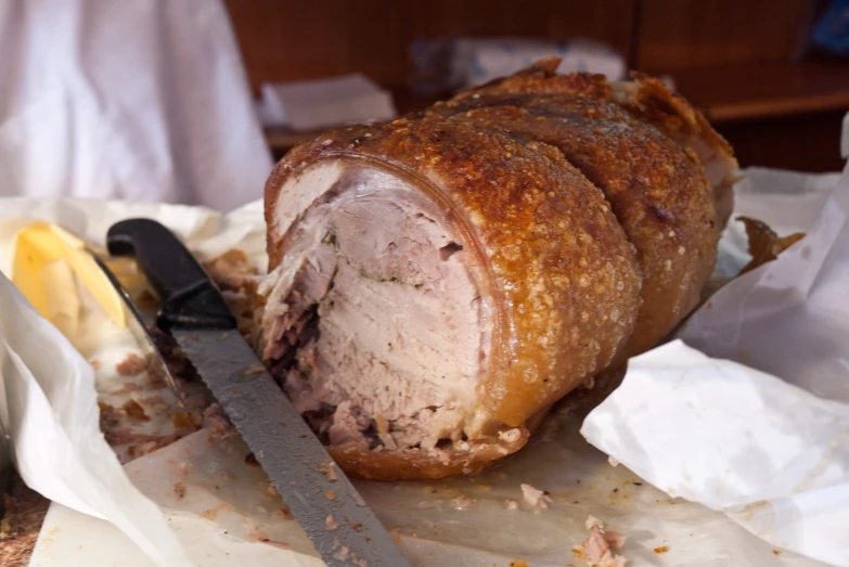 a pork roast sliced into thick pieces with knife