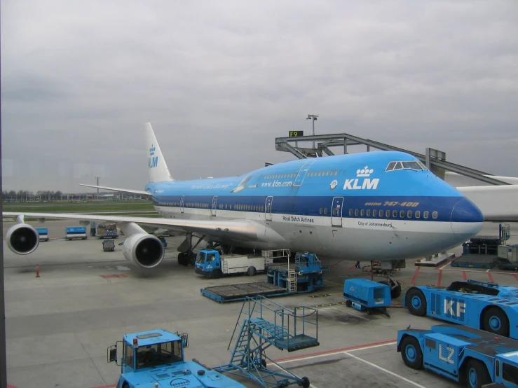 an airplane parked in an airport and trucks around it