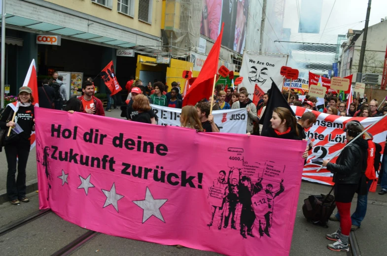 the large group of people is holding a banner