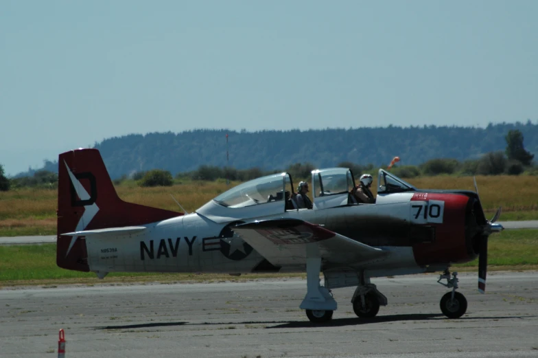 a red white and black plane on an airport runway