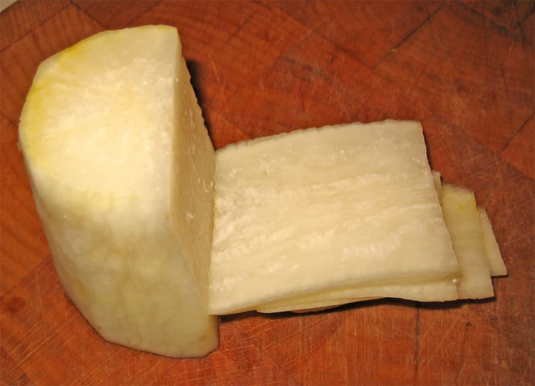 sliced cheese wedged into quarters on wooden surface