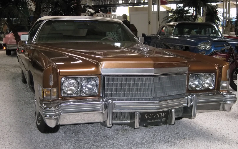 a brown and white car parked in a parking lot