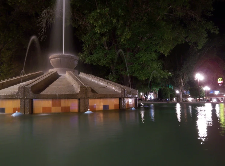 water gushing into the side of a fountain at night