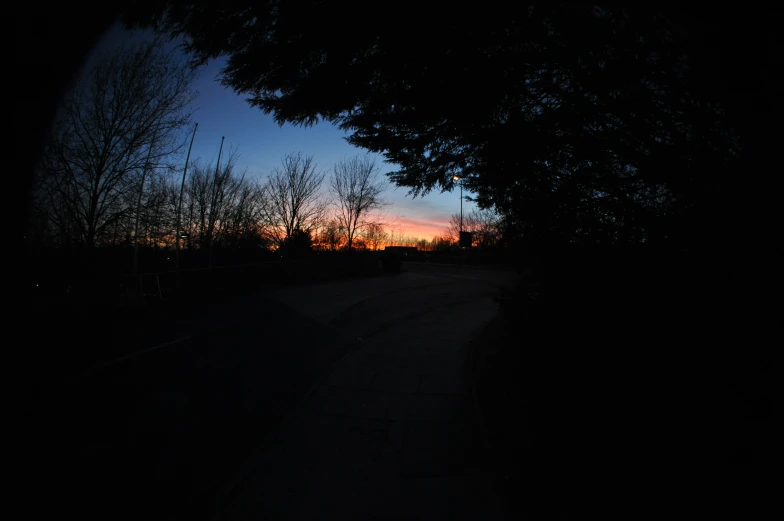 the sun is setting in the background over a street