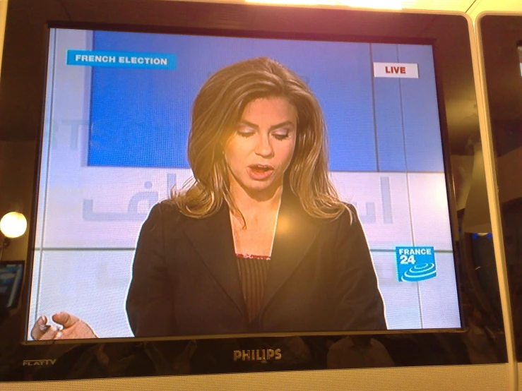 a woman in a suit speaking on a television screen