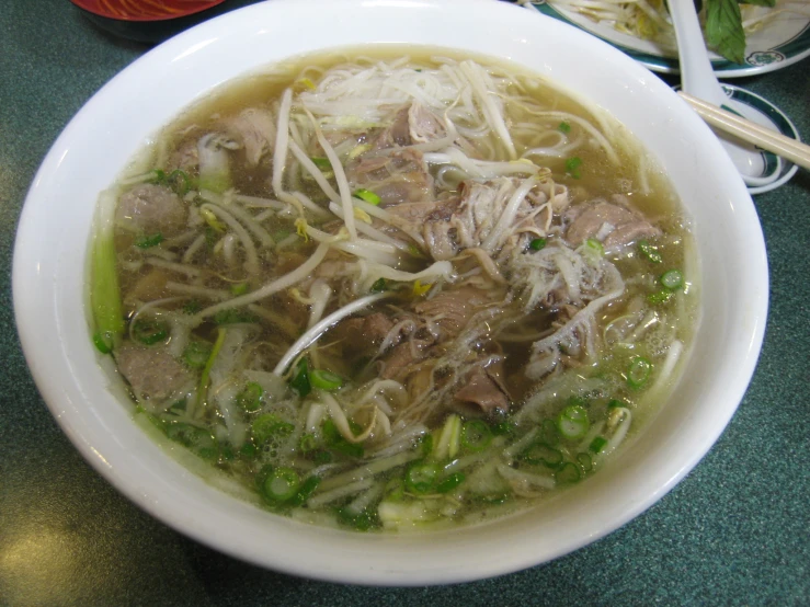 a white bowl filled with soup and meat