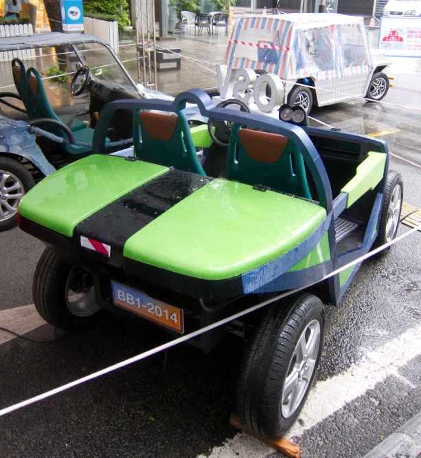 several vehicles parked on the side of a road with green and black seats